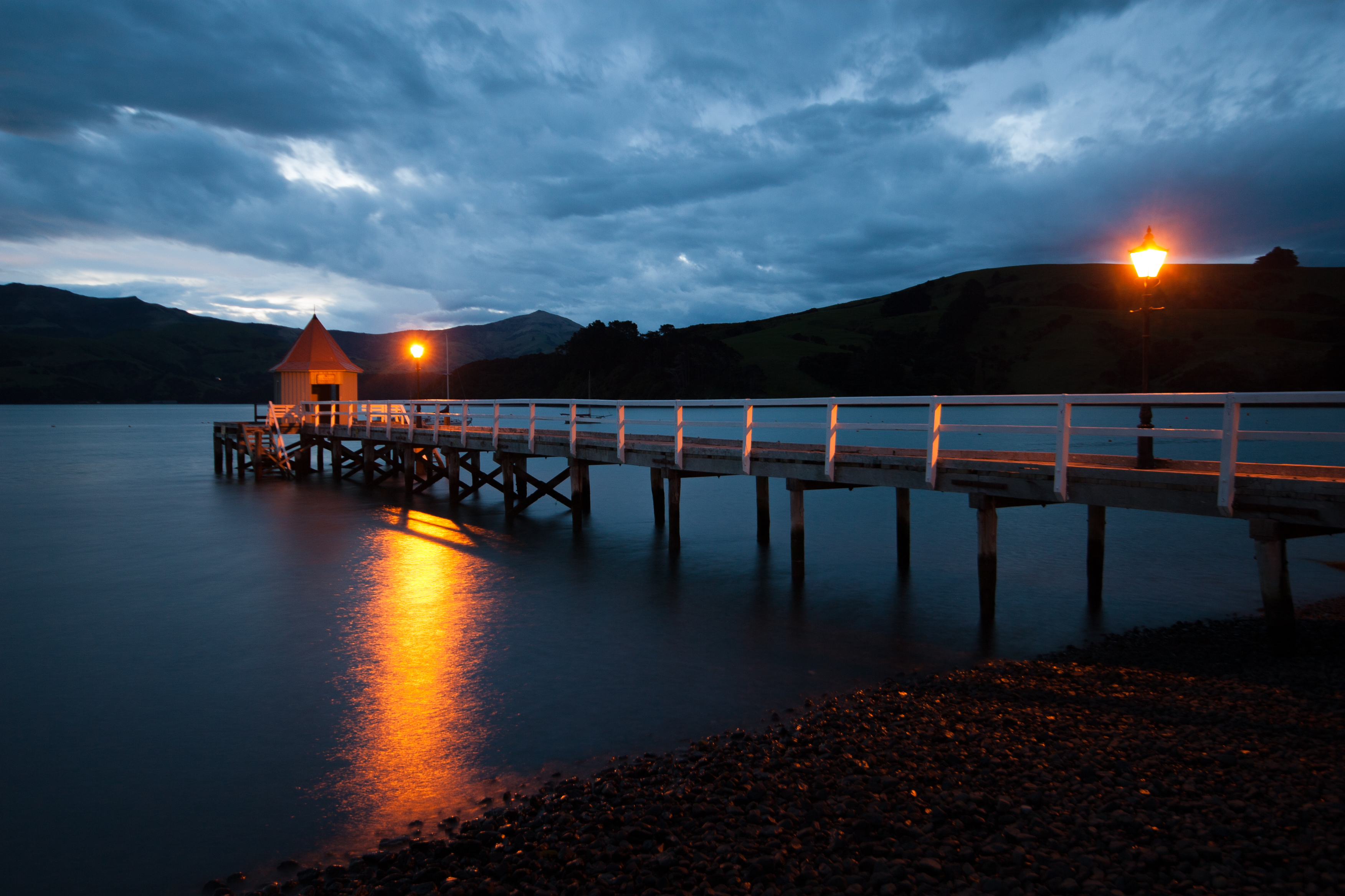 pier or jetty in Akaroa, canterbury, new zealand at night with reflection on water