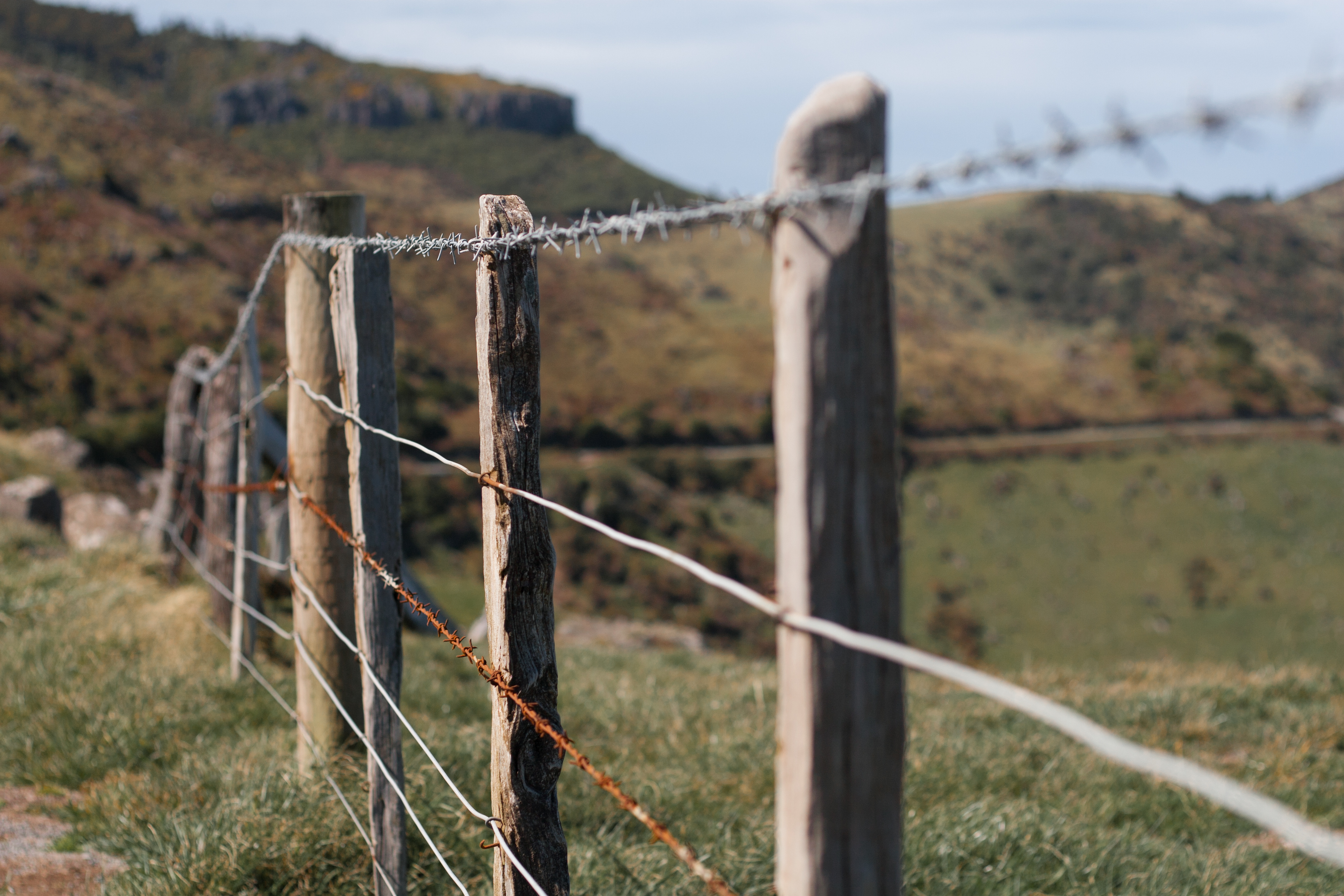 rusted barbed wire on a rural fence post