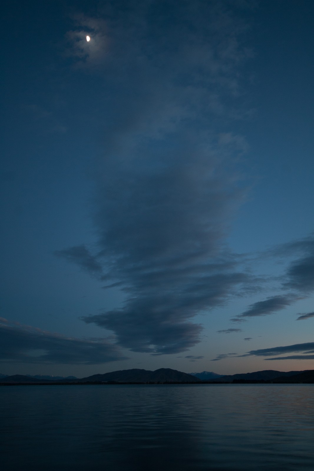 just before sunrise, view of lake and clouds with moon visible top of frame