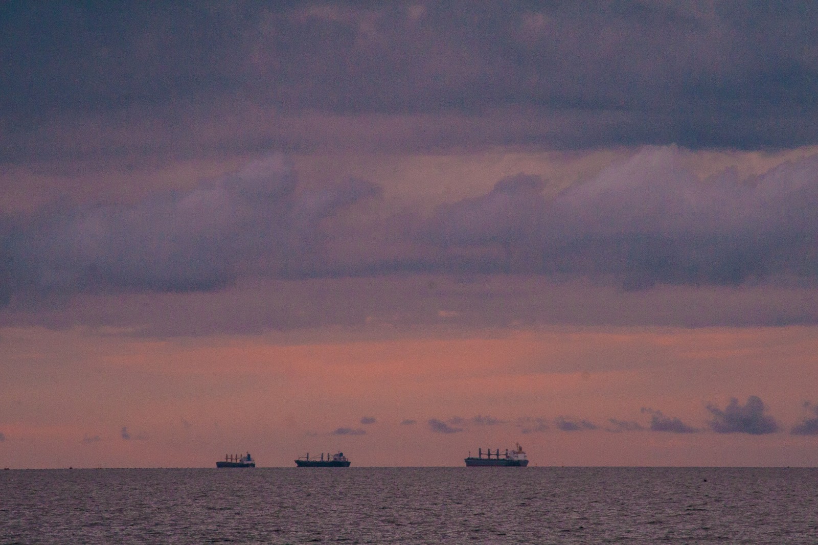 boats on the horizon near sunset
