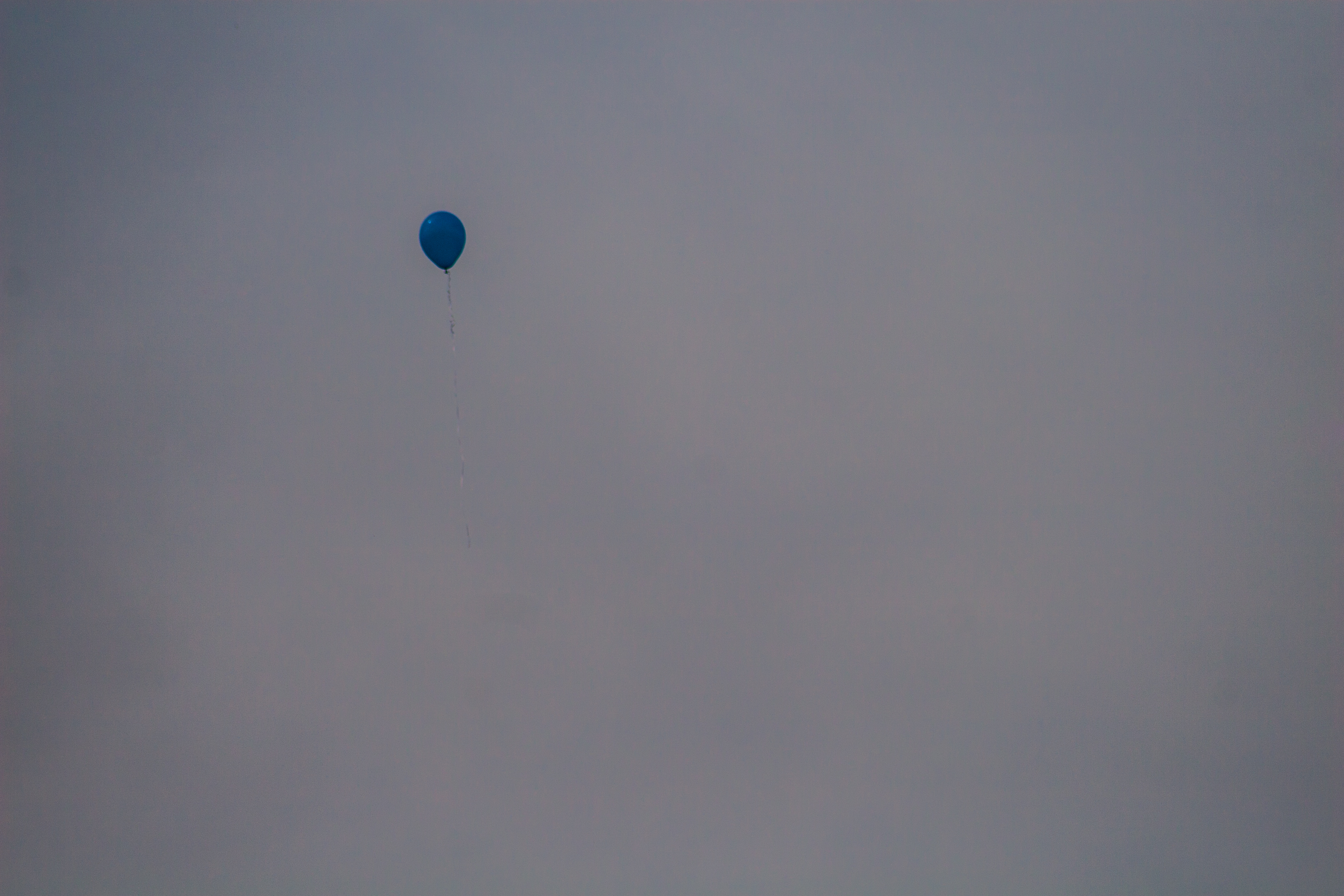 a single solitary balloon flying up into the sky